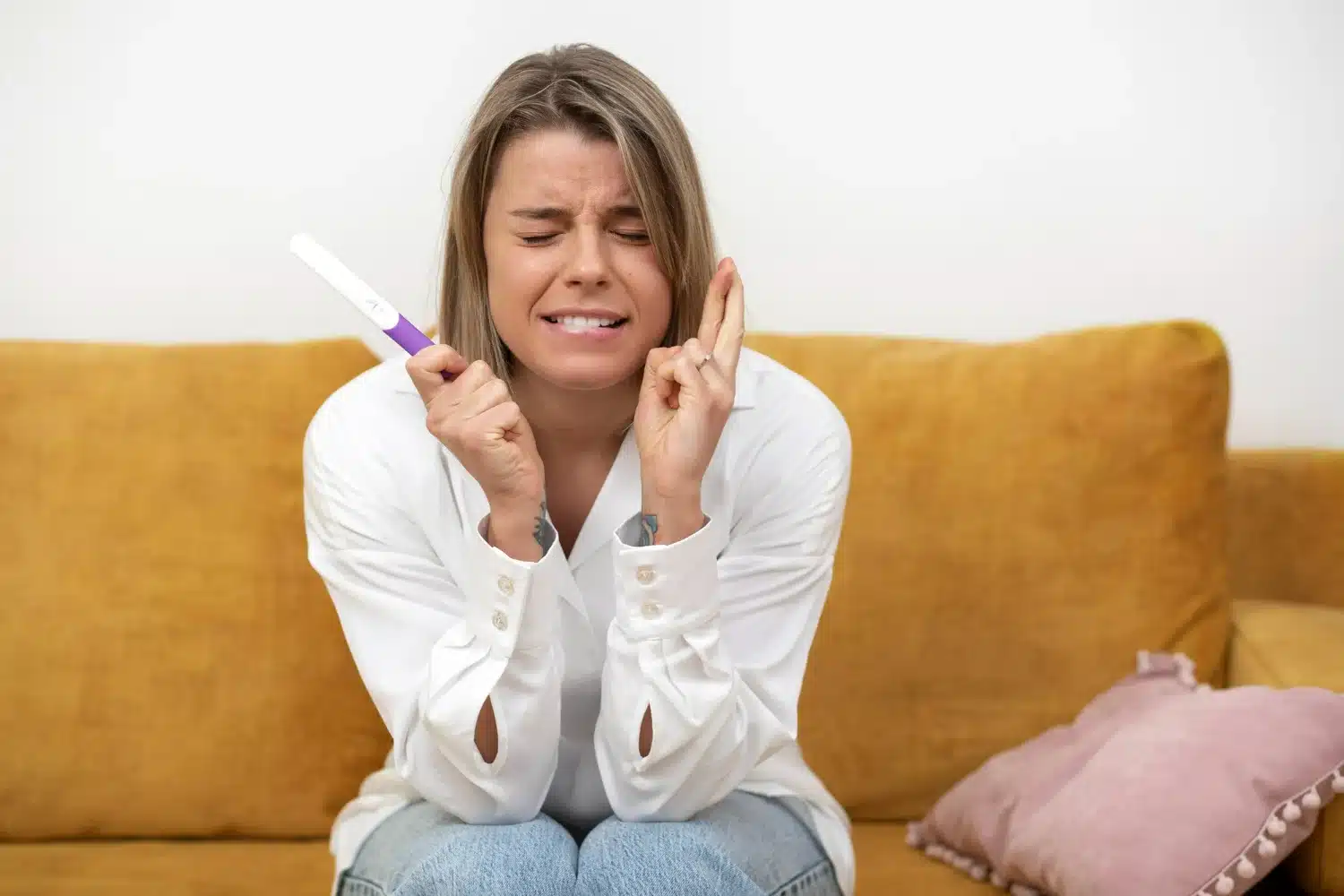 Mulher segurando um teste de gravidez, torcendo para que seu teste de gravidez de positivo