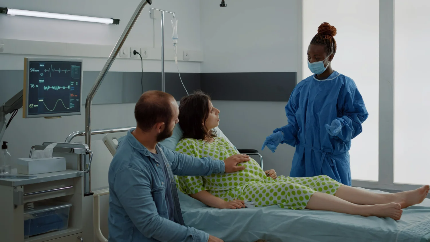 Mulher gravida com seu marido conversando com uma enfermeira representando o descolamento de placenta