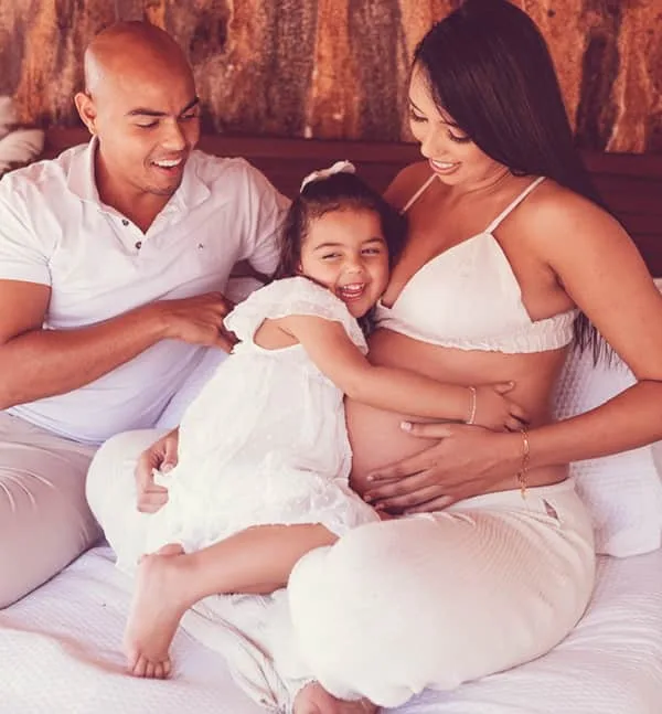 Família unidade em torno da mamãe grávida.