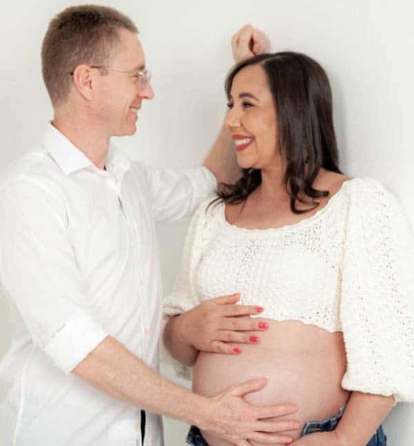 Marido com a mãos sobre a barriga da mulher grávida