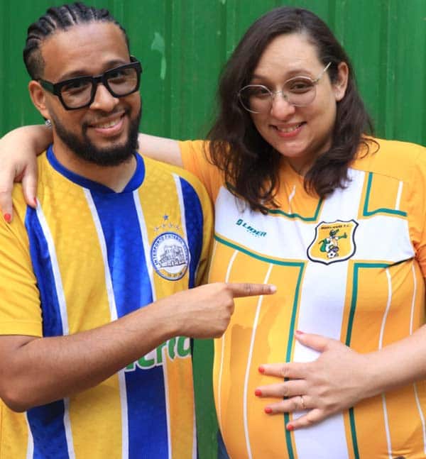 Marido apontando para barriga da esposa grávida